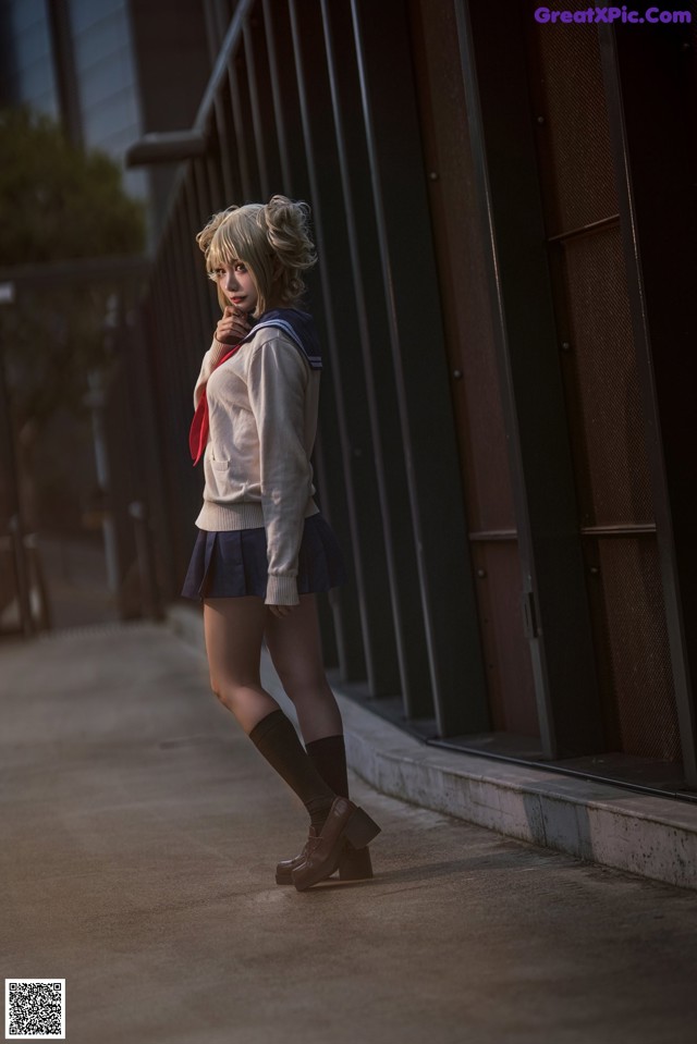 A woman in a school uniform is walking down the street.
