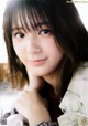 A woman with long brown hair and bangs posing for a picture.