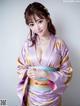 A woman in a purple kimono posing for a picture.