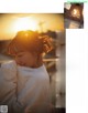 A woman in a white sweatshirt is looking at the sunset.