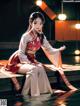 A woman in a red and white kimono sitting on a dock.