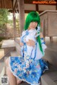 A woman with green hair sitting on a wooden bench.