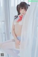 A woman in a white lingerie sitting on a window sill.