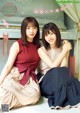 Two young women sitting next to each other in front of a piano.