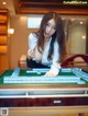 A woman playing a game of mahjong on a table.