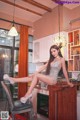 A woman sitting on top of a wooden table in a kitchen.