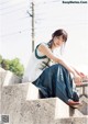 A woman sitting on the steps of a building.