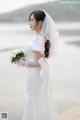 A woman in a wedding dress holding a bouquet of flowers.