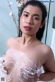 A woman is taking a bath with foam on her breasts.