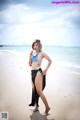 A woman in a bikini standing on a beach.