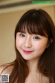 A woman with long brown hair and a red lipstick.